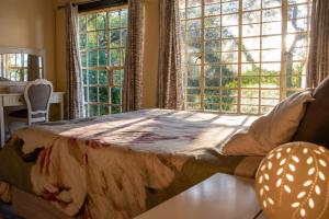 a bedroom with a large bed and two windows at OPPIBERG GUEST HOUSE and SPA in Hartbeespoort