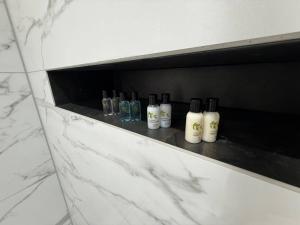 a row of bottles sitting on a shelf in a bathroom at Auberge Hotel by Sasco in Lytham St Annes