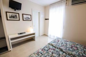a bedroom with a bed and a television at Hotel Tarconte in Tarquinia