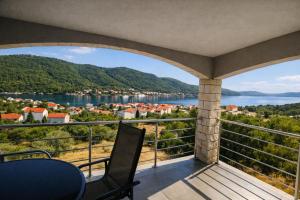 a balcony with a view of a town and water at Apartments VillaMare in Grebaštica