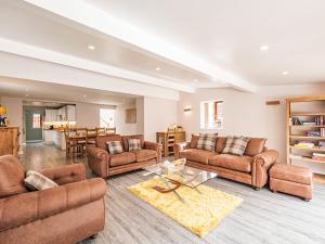 a living room with couches and a table at Stuarts Farm Barn in Westhead