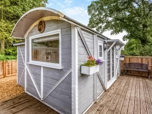 a shed with a door and a window on a deck at Lovers Carriage - Uk46404 in Cowbridge