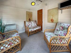 two wicker chairs and two chairs in a room at Bramble Grange in Derby