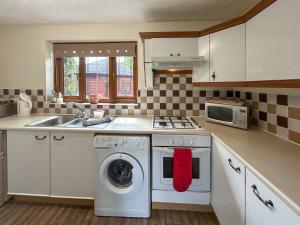 a kitchen with a washing machine and a sink at Bramble Grange in Derby
