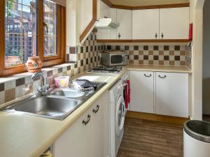 a kitchen with a sink and a washing machine at Bramble Grange in Derby +8 photos