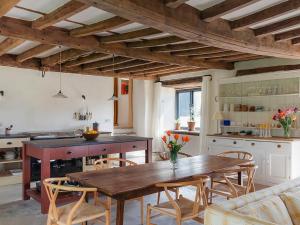 a kitchen with a wooden table and chairs at Blaenau - Uk50400 in Llanstephan +11 photos
