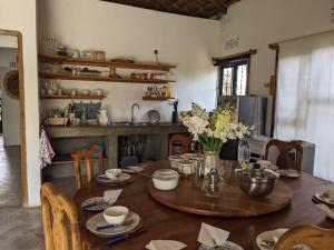 a dining room with a wooden table with flowers on it at Giraffe Gallery Home in Arusha