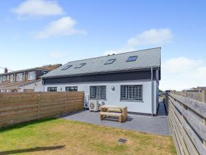 a white house with a fence and a bench at Sea Skapya - Uk50178 in Helston