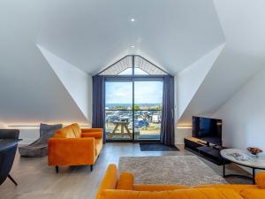 a living room with orange furniture and a large window at Sea Skapya - Uk50178 in Helston