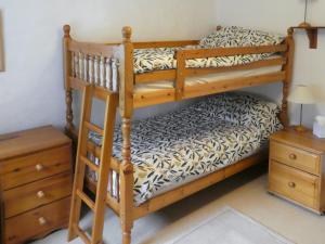 a bedroom with two bunk beds and a night stand at Chapel Cottage in Askham