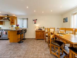 a kitchen with a wooden table and a dining room at Derwen Haidd in Llanafan