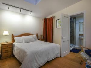 a bedroom with a bed and an open door at Sheldon Cottage in Bishops Castle +12 photos
