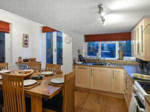a kitchen with a wooden table and a dining room at Sheldon Cottage in Bishops Castle