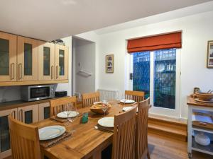 a kitchen and dining room with a wooden table and chairs at Sheldon Cottage in Bishops Castle