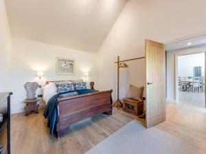 a bedroom with a bed and a sliding glass door at Maple Barn in Eye