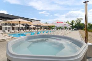 a large swimming pool with chairs and umbrellas at ROMANTIK in Solotvyno