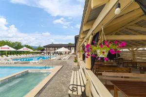 a pool at a hotel with benches and flowers at ROMANTIK in Solotvyno