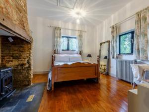 a bedroom with a bed and a fireplace at Pettingalls Farm Cottage in Great Ellingham