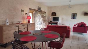 a kitchen and living room with a table and chairs at La maison des charretiers in Cohiniac