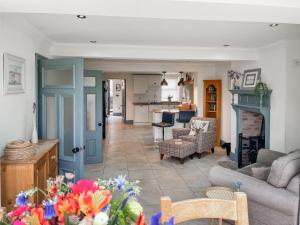 a living room with a couch and a kitchen at Old Master's Cottage in Leven