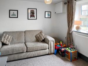 a living room with a couch and a window at Old Master's Cottage in Leven