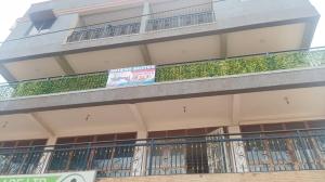 a building with a balcony with plants on it at Rasaf Cottages and Intent suits in Kyebando