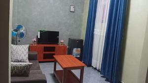 a living room with a tv and a coffee table at Rasaf Cottages and Intent suits in Kyebando