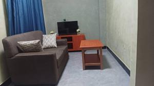 a living room with a couch and a table at Rasaf Cottages and Intent suits in Kyebando