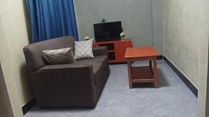 a living room with a couch and a table at Rasaf Cottages and Intent suits in Kyebando +2 photos