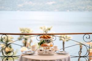 a table with cups and plates of food on it at Ca Meison in Cannobio