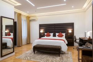 a large bedroom with a large bed and a mirror at Bolton White Hotel in Abuja