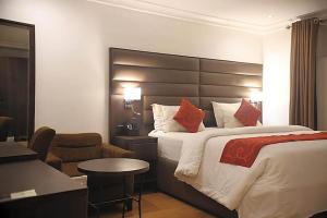 a hotel room with a large bed and a chair at Bolton White Hotel in Abuja