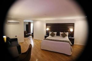 a bedroom with a large bed with a large headboard at Bolton White Hotel in Abuja