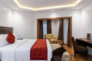 a hotel room with a bed and a desk and a computer at Bolton White Hotel in Abuja