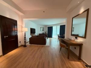 a living room with a desk and a couch and a table at Arabian Palace Hotel in Al Rahba