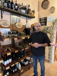 a man standing in front of a shelf of wine bottles at Art & Breakfast in Ripabottoni +41 photos