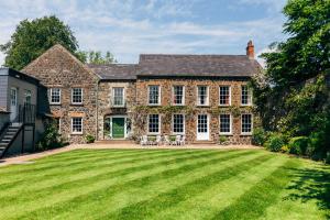 an old brick house with a large lawn at Dunadry Hotel And Gardens in Antrim