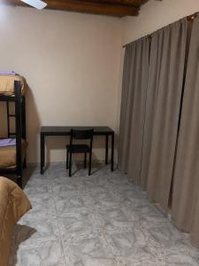 a table in a room with a chair and a curtain at Talahuasto in Los Baldecitos
