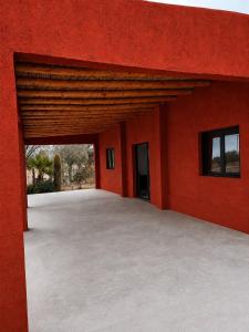 a large red building with a large patio at Talahuasto in Los Baldecitos