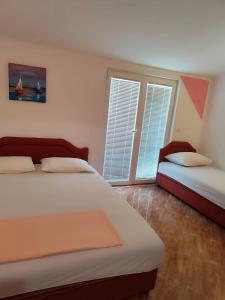 a bedroom with two beds and a window at Apartmani Šušanj in Bar
