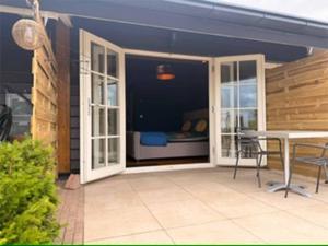 a patio with a table and a room with a bed at De Hombrake, Bed & Breakfast in Wilp