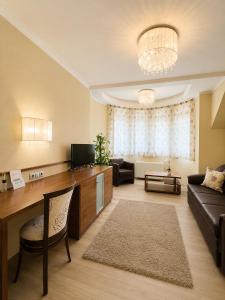 a living room with a couch and a tv at Mizse Motel in Lajosmizse