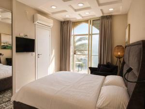 a hotel room with a bed and a chair and a window at Safra - Hotel rooms in Tel Aviv