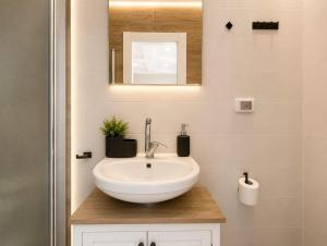 a bathroom with a white sink and a mirror at Safra - Hotel rooms in Tel Aviv