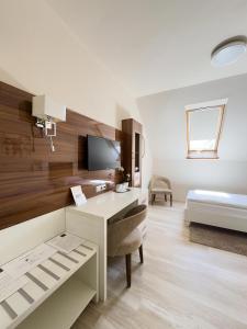 a white room with a desk and a bed at Mizse Motel in Lajosmizse +48 photos