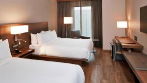 a hotel room with two beds and a desk at AC Hotel by Marriott Minneapolis Downtown in Minneapolis