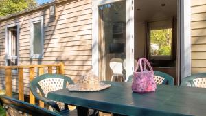 a table with two hats and a purse on a porch at Chalet charmant à Saint-Jean-du-Gard in Saint-Jean-du-Gard