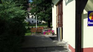 a walkway with two benches and a building at Apartments Zámoček Staré časy in Poprad