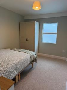 a bedroom with a bed and a cabinet and a window at The Gate House in Galway