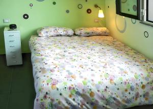 a bedroom with a bed with a comforter and pillows at Comfortable Studio in Nicolosi, 25 m² in Nicolosi